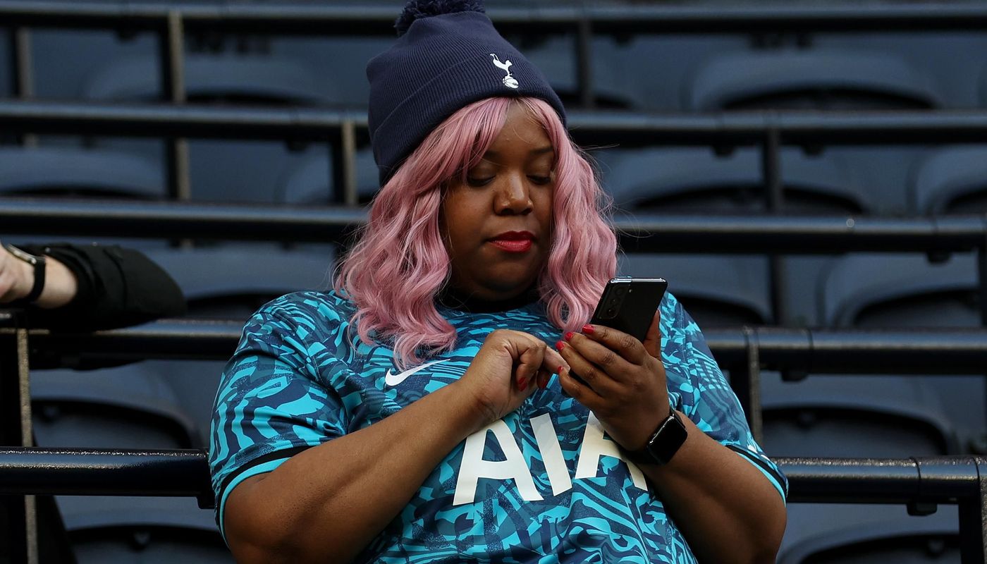 Spurs fan checks her phone
